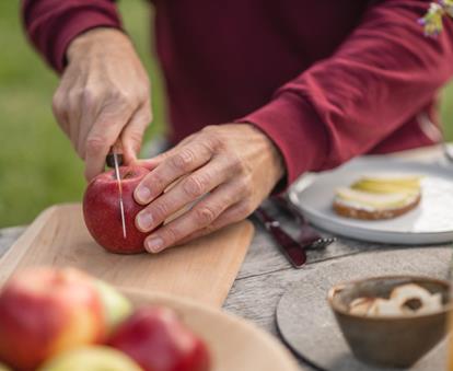 Freshly sliced South Tyrolean apple on a wooden board during a picnic.