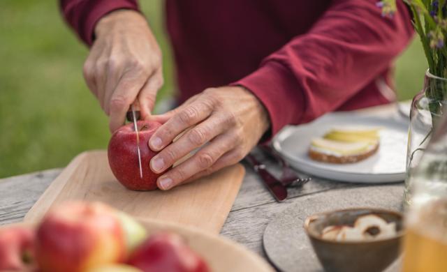 Freshly sliced South Tyrolean apple on a wooden board during a picnic.