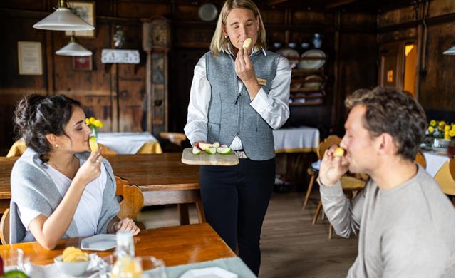 Apple sommeliers guiding two people during a tasting, smelling the apple.